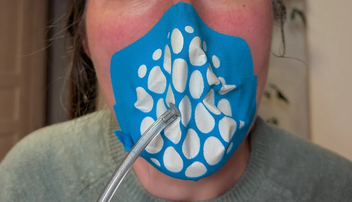 The Proper Mask auf einem Gesicht beim Fit-Test, mit einem Messschlauch durch die Maske